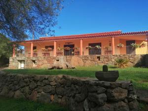 ein Haus mit einer Steinmauer davor in der Unterkunft Agriturismo Conca' e Janas in Dorgali