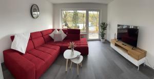 a living room with a red couch and a table at Unique geräumige 4 Zimmer Wohnung in Tuttlingen mit Netflix, Sauna und Fitness in Tuttlingen