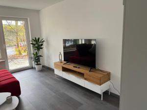 sala de estar con TV de pantalla plana en una pared blanca en Unique geräumige 4 Zimmer Wohnung in Tuttlingen mit Netflix, Sauna und Fitness en Tuttlingen