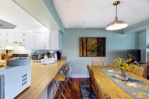 una cocina con una gran mesa de madera en una habitación en Saltbox 10B, en White River Junction