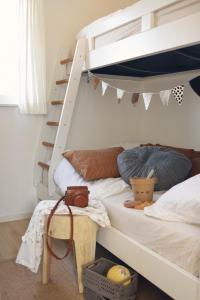 een slaapkamer met een stapelbed en een ladder bij Strandplekje in Callantsoog