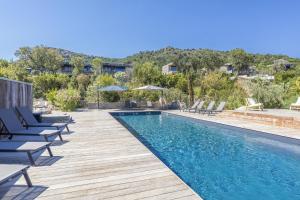 una piscina con tumbonas y sillas alrededor en Appartement Stella en Sainte-Lucie de Porto-Vecchio