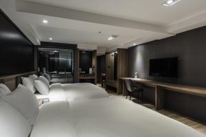 een hotelkamer met twee bedden en een flatscreen-tv bij Autumn Willow Hotel in Taichung