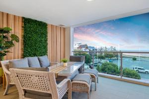 a balcony with a table and chairs and a large window at Suite 3201 Three Bedroom Luxe Oceanview Apartment in Mandurah