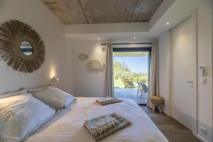 een slaapkamer met een groot bed en een spiegel bij Appartement Luna in Sainte-Lucie de Porto-Vecchio