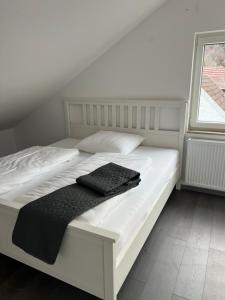 a white bed with a black blanket on it at Unique geräumige 2 Zimmerwohnung in Tuttlingen mit Netflix, Sauna und Fitness in Tuttlingen