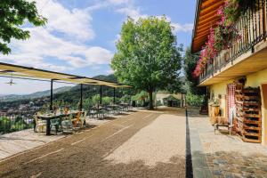 un patio avec des tables et des chaises et un bâtiment dans l'établissement AGRITURISMO CA' FENILE, à Alzano Lombardo