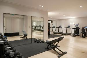 um ginásio com um espelho e linhas de equipamento de exercício em Kalesma Mykonos em Ornos