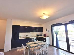 una cucina e una sala da pranzo con tavolo e sedie di Joli appartement face à la mer- St Florent a Saint-Florent