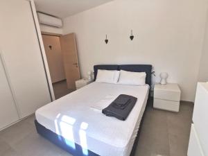 una camera da letto con un letto con una camicia nera sopra di Joli appartement face à la mer- St Florent a Saint-Florent