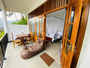 a balcony with a bedroom and a bed and a table at Misty peak view in Ella