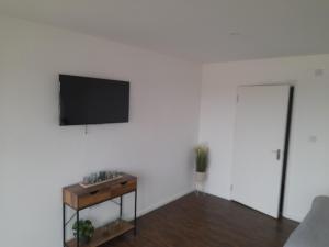 ein Wohnzimmer mit einem TV an einer weißen Wand in der Unterkunft Weston Lawns Lodges in Bulkington