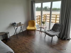 a living room with two chairs and a table at Weston Lawns Lodges in Bulkington