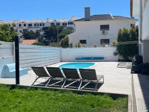 a group of chairs sitting next to a swimming pool at Seaside Place Cascais in Carcavelos
