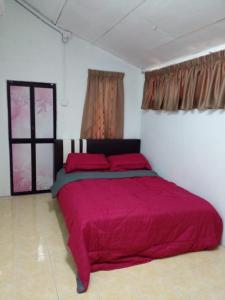 1 dormitorio con 1 cama roja en una habitación en RZ Homestay en Kuala Terengganu