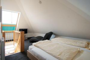 グローセンブローデにあるStrandpark-Grossenbrode-Haus-Wolkenlos-Wohnung-11-Cloud-Elevenのベッドルーム1室(ベッド1台、椅子、窓付)