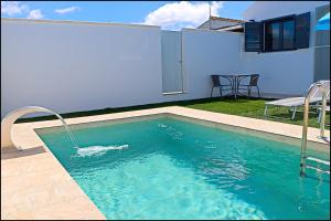 una piscina davanti a una casa di Chalet los Morenos a Conil de la Frontera