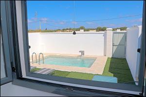 una finestra con vista sulla piscina di Chalet los Morenos a Conil de la Frontera Altre 14 foto