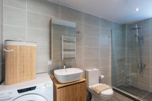 a bathroom with a sink and a toilet and a shower at Greek Sky - New modern apartment with shared pool in Tavronitis