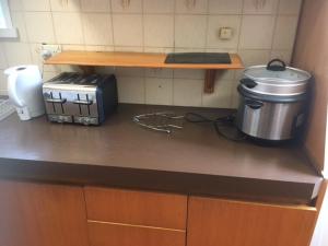 a kitchen counter with a slow cooker and a toaster at A1 Holiday home close to train station in Mitcham