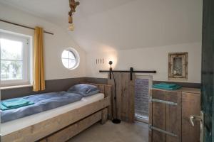 een slaapkamer met een houten bed en een raam bij Vakantiehuisje aan de rand van Arnhem in Arnhem