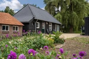 een huis met een tuin met paarse bloemen bij Vakantiehuisje aan de rand van Arnhem in Arnhem