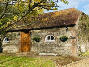 an old brick building with a wooden door at The Stable - For A Unique Retreat in Hooe