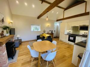 een keuken en een woonkamer met een tafel en stoelen bij The Stable - For A Unique Retreat in Hooe