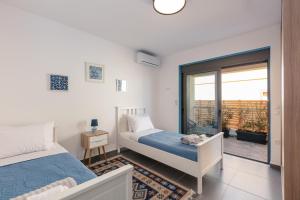 a bedroom with two beds and a balcony at Greek Sky - New modern apartment with shared pool in Tavronitis