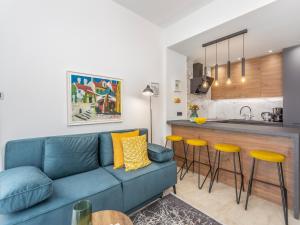 salon z niebieską kanapą i kuchnią w obiekcie Vila Klara Malinska w mieście Porat