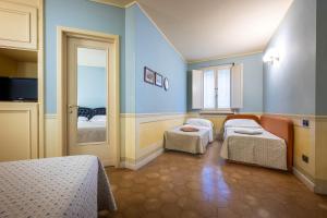 Habitación con 2 camas y puerta a un dormitorio en Hotel San Luca, en Spoleto