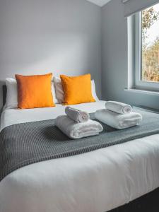 - une chambre avec un lit et des serviettes dans l'établissement Broadford Lodges Skye, à Broadford
