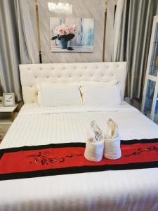 Un dormitorio con una cama con dos zapatos. en The Star Hotel, en Udon Thani