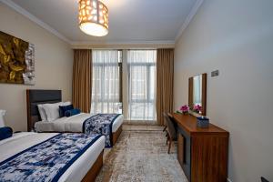 um quarto de hotel com duas camas e uma secretária em Al Gassar Resort em Doha