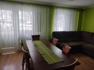 sala de estar con mesa y sofá en Przy Parku, en Jarosław