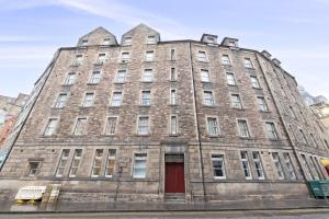 a large brick building with a red door at ALTIDO Gorgeous Old Town Flat in Edinburgh