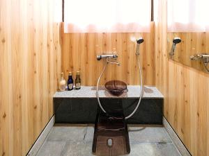 a bathroom with a shower with a wooden wall at 宮古島 Guesthouse Re-Spect in Miyako Island