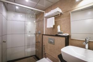 a bathroom with a shower and a sink and a toilet at Townbridge Hotels & Suites in Cochin