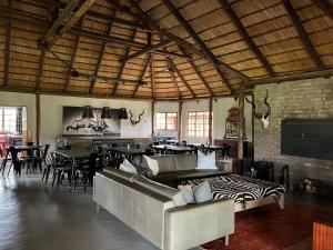 een grote kamer met een bank en een tafel bij Vilagama Game Lodge in Mookgophong