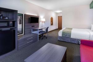 a hotel room with a bed and a desk at Super 8 by Wyndham Ambassador Bridge Windsor ON in Windsor