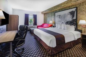 a hotel room with a large bed and a desk at Super 8 by Wyndham Ambassador Bridge Windsor ON in Windsor