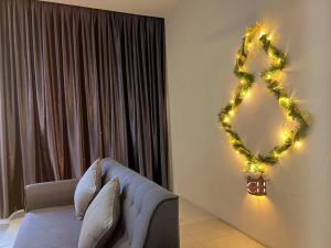 King bed Kuching Stutong Heights Apartment Nearby Airport في كوتشينغ: غرفة معيشة مع إكليل عيد الميلاد على الحائط