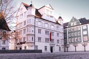 ein großes weißes Gebäude neben zwei kleineren Gebäuden in der Unterkunft Der Fürstenhof in Kempten