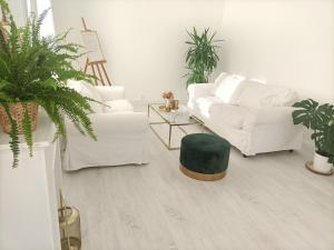 sala de estar con sofá blanco y reposapiés verde en Guibert Home - Appartement spacieux à 20 min de Paris, en Villeneuve-le-Roi
