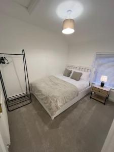 ein weißes Schlafzimmer mit einem Bett und einem Spiegel in der Unterkunft Mount Cottage in Conwy