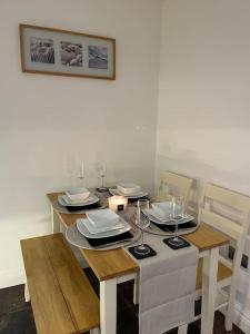 a dining room table with plates and wine glasses at Mount Cottage in Conwy