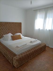 1 cama grande con cabecero grande en un dormitorio en Guibert Home - Appartement spacieux à 20 min de Paris, en Villeneuve-le-Roi
