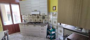 una cocina con armarios blancos y fregadero en Casa a Cocca, en Briatico