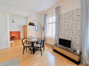 a living room with a table and chairs and a tv at Beautiful Flat Next to Karlskirche in Vienna