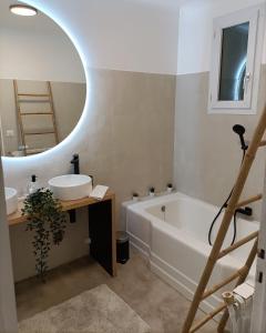 y baño con bañera, lavabo y espejo. en Guibert Home - Appartement spacieux à 20 min de Paris, en Villeneuve-le-Roi
